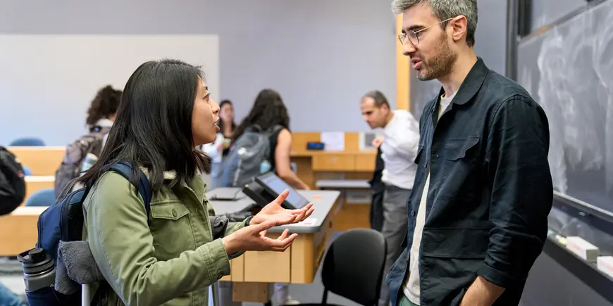 Megan Hung talks with Eric Moch in an MIT Sloan lecture hall.