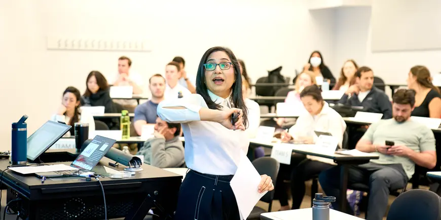 Arathi Mehrotra gestures to a projected image as she teaches a class of MIT Sloan students