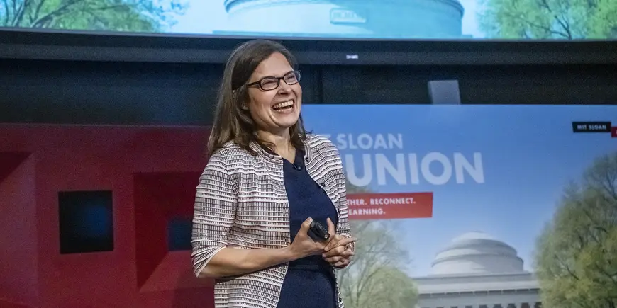 A smiling woman stands onstage