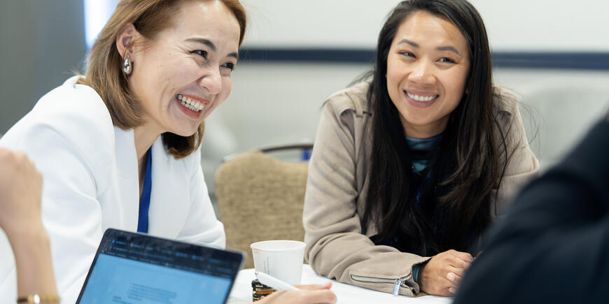 Photo of two women smiling at a table