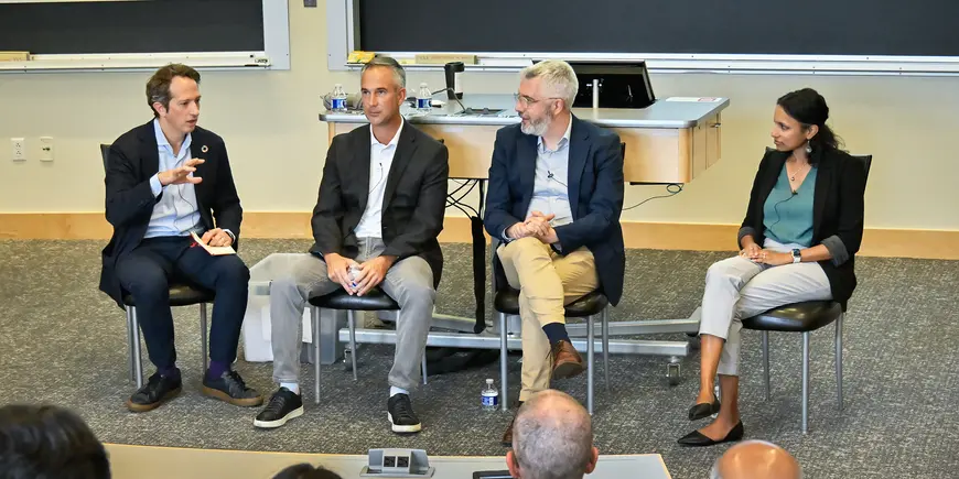 Four panelists discuss a topic in front of an audience