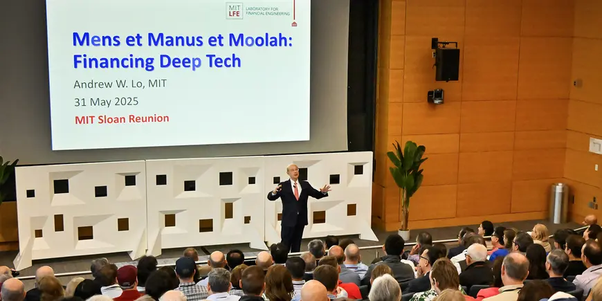 A man presents to a packed auditorium