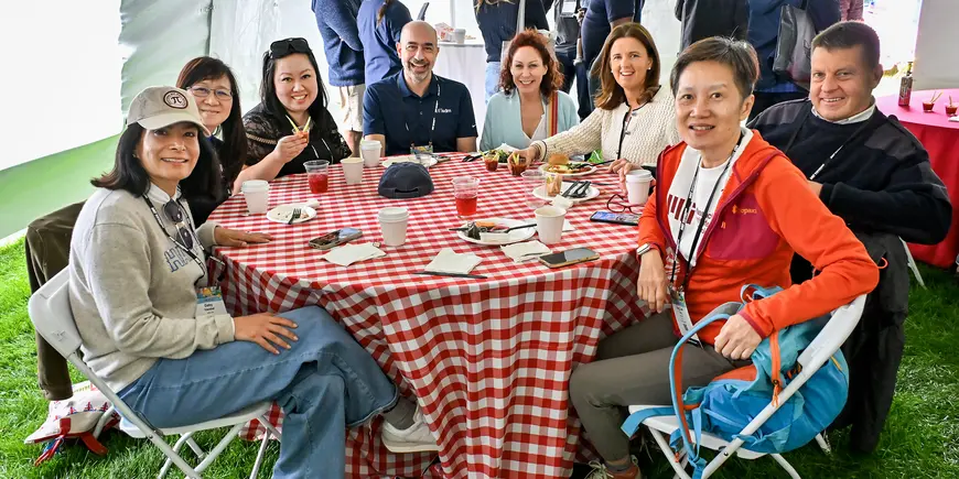 A group at a picnic table poses for a photo