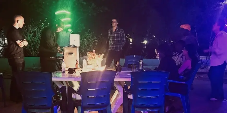 Picture of host and students at night with green light.