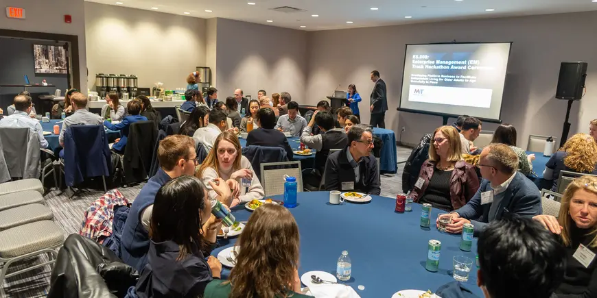 Students, faculty and staff sitting at tables