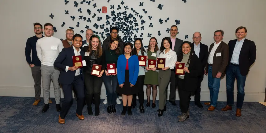 Hackathon 2023 winners posing in front of a decorative wall