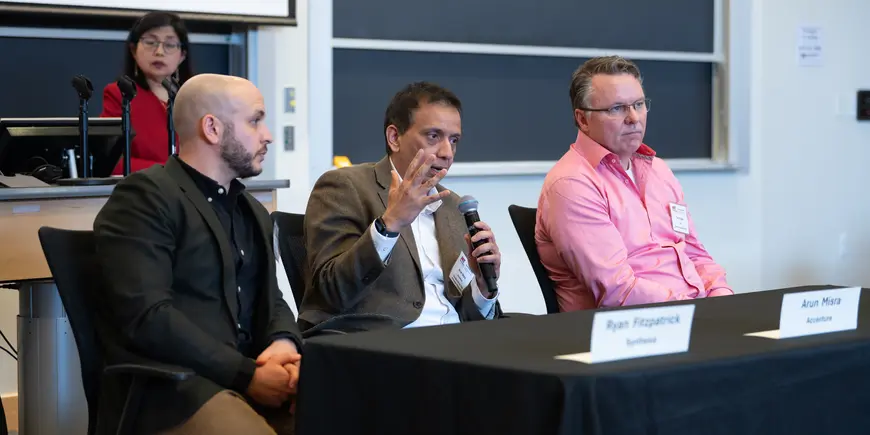Three Hackathon 2025 panelists sitting at a table
