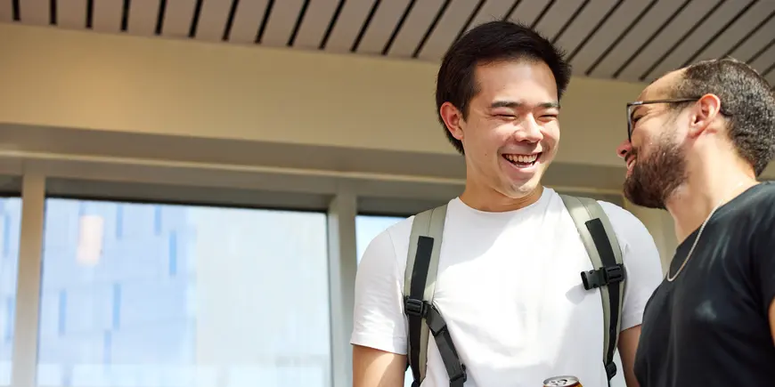 Patrick Yeung and another student stand outside. They are smiling and talking