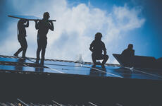 four people installing solar panels