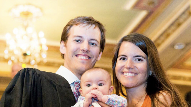 MBA graduate with partner and baby at convocation