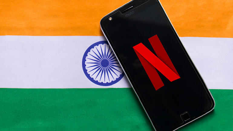 Cell phone with Netflix icon on top of an Indian flag