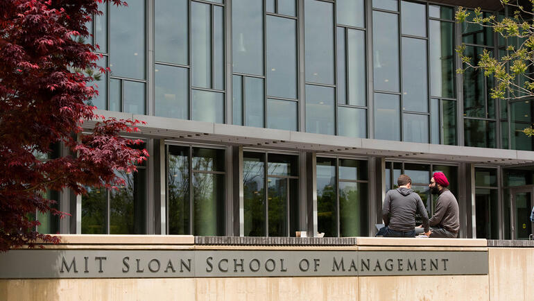 MIT Sloan students converse outside building E62.