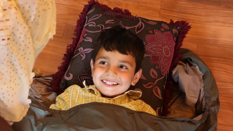 A young child gets comfortable in a TravlerPack sleeping bag.