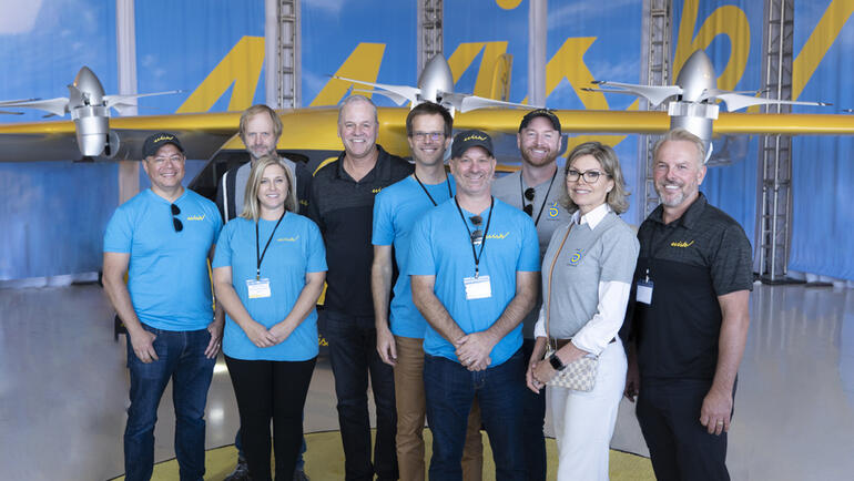 Caption:Leon Villegas (left) stands with the Wisk Aero executive team at the launch of their Generation 6 aircraft.