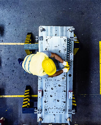  aerial image of worker in a hard hat surrounded by manufacturing equipment