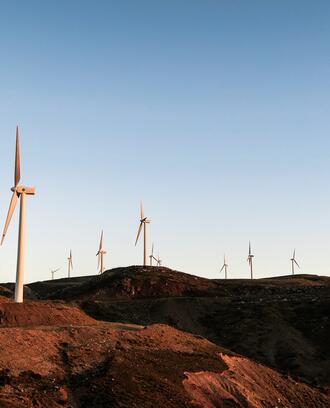 Photo of dozens of wind turbines on rocky landscape.