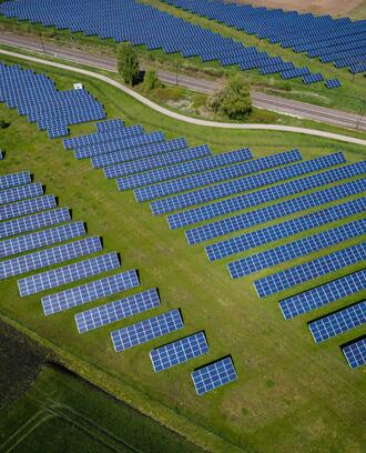 Solar panels appear in a field emphasizing the environmental aftermath of COVID-19. 