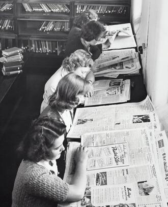 Vintage photo of women reading the newspaper.