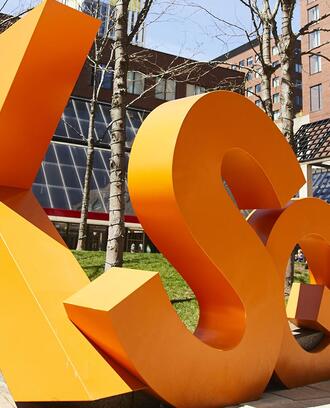 A sculpture of Kendall Square's initials in front of the Boston Marriott Cambridge.