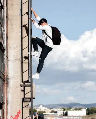 Image of a Man With Backpack Climbing a Ladder