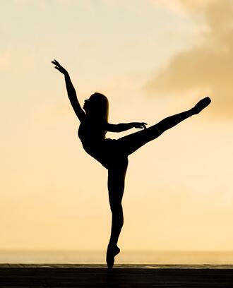 Silhouette of ballerina dancing in the sunset