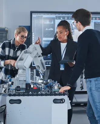 Female Teacher and Two Students Work With Prototype of Robotic Hand