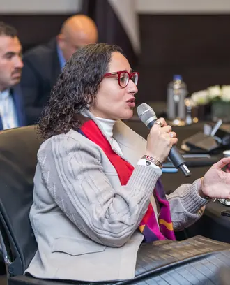 Seated woman asking a question using a microphone