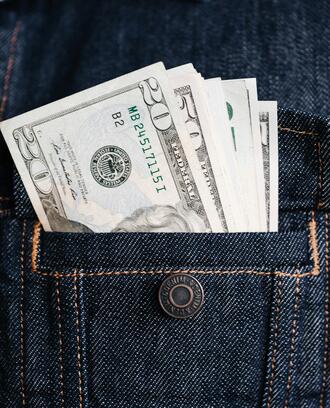 Image of a denim jacket's pocket, with money in it