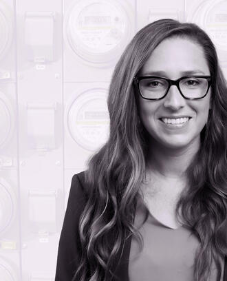 Jacqueline Pless amongst a background of digital electricity meters