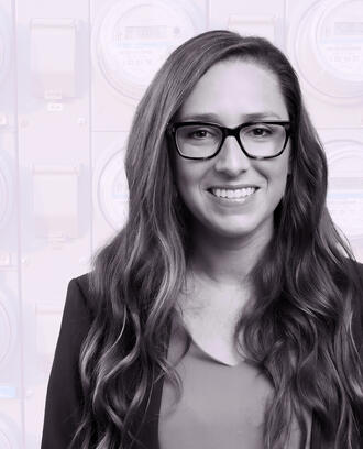 Jacqueline Pless amongst a background of digital electricity meters