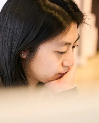 Megan Hung looks down with her head in her hands. 