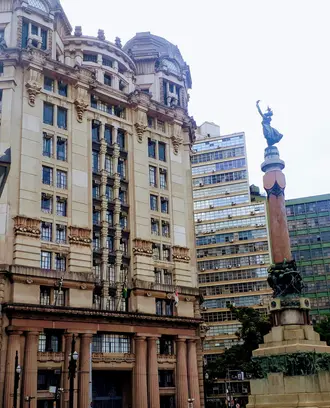 A tall building with a statue in front of it. 