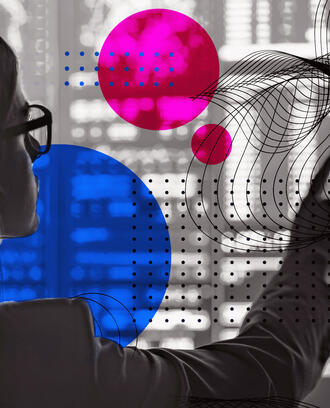 A worker points to a screen covered in code and geometric shapes