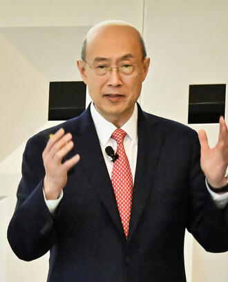 A person delivers a lecture to a crowded auditorium