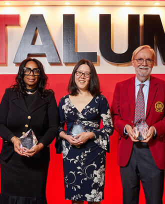 Group of people stands on stage holding awards