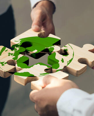 hands assembling climate jigsaw puzzle