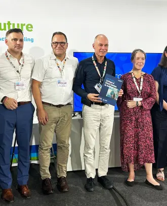 Event panelists, moderator, and organizers stand together.