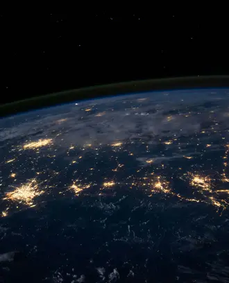 space level view of the earth, lights of major cities visible 