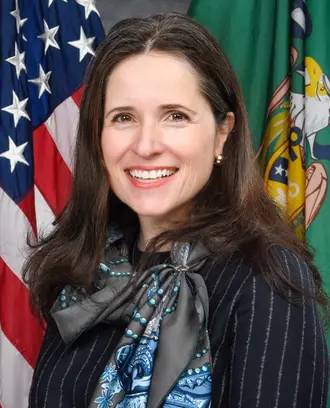 Closeup image of woman smiling with flags behind her. 