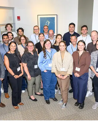 Group of 27 people stand and pose for a picture. 