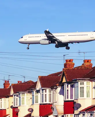 An airplane flies low over a neighborhood