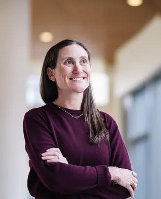 Laura in a maroon sweater crossing her arms
