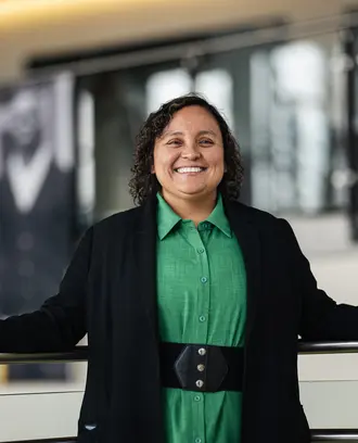Solangel Fernandez in a green dress and black sweater