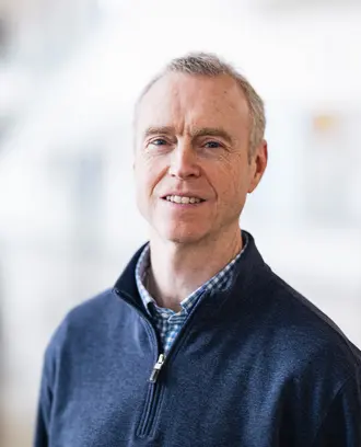 David Miller in front of blurry white background