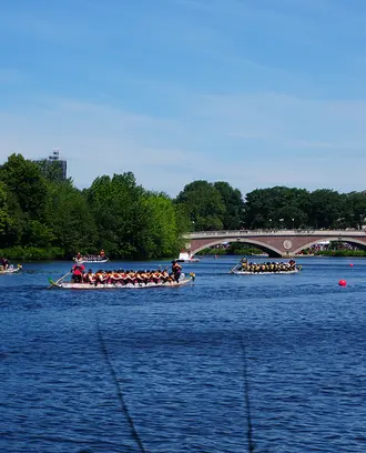 Several boats race down the Charles River in Cambridge