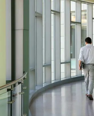 Man walking on the indoor bridge connecting building E62 with E52.