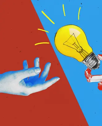 A human hand and a robot hand holding a lightbulb