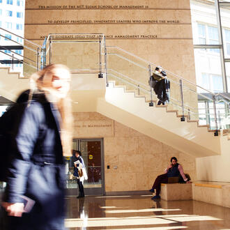 students walk through lobby with staircase