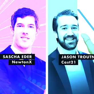 two men smiling in front of a pink and blue background