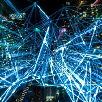 Time lapse of cables in front of city representing data flowing through economy.